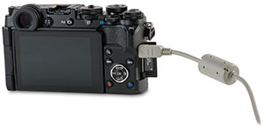 Olympus PEN-F camera with door open and USB cable transfer
